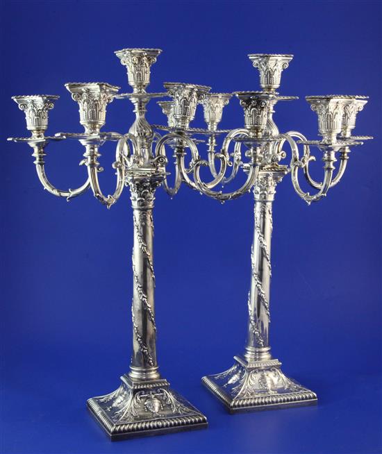 A harlequin pair of Edwardian silver corinthian column five light four branch candelabra, weighted.